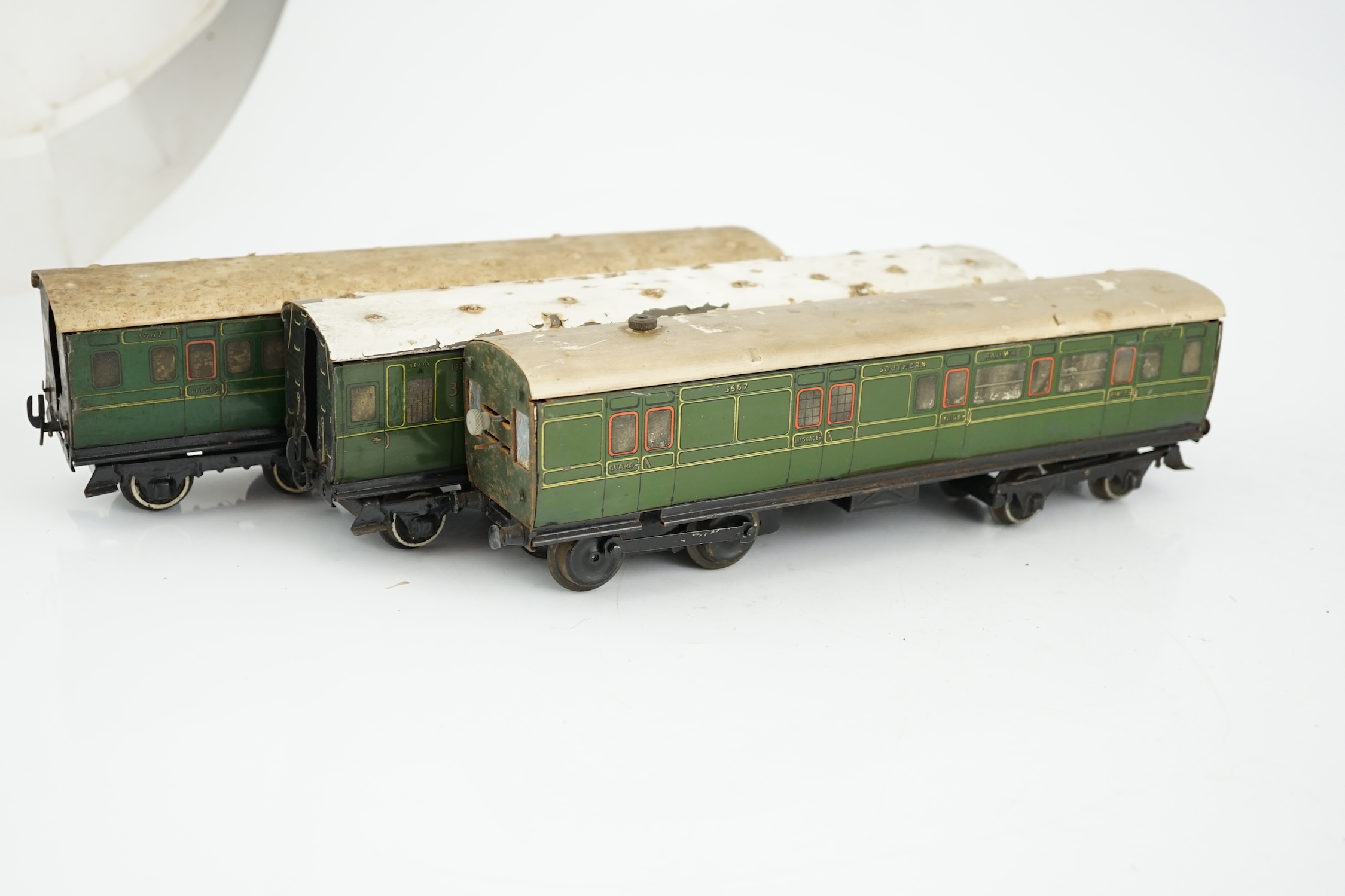 Six Hornby 0 gauge tinplate No.2 coaches in Southern Railway livery, one coach adapted to a driving unit with clockwork motor and replacement bogie